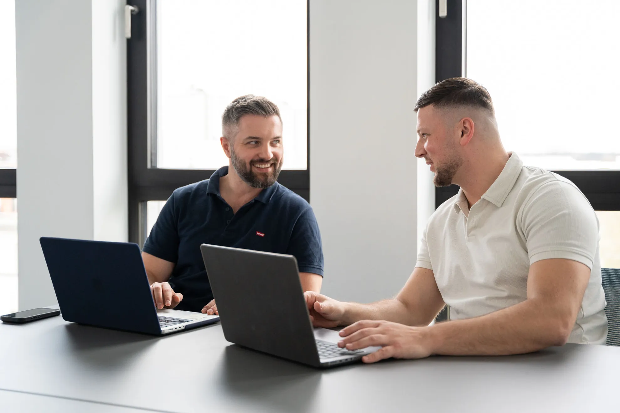 2 Mitarbeiter am Laptop und reden miteinander